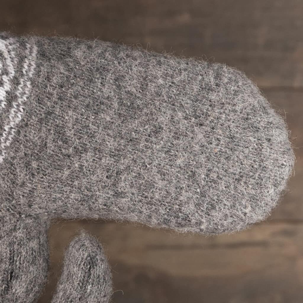 Schöne warme Wollfäustlinge für Männer in Dunkelgrau mit hübschem Motiv in Weiß. Warme Fäustlinge für Männer in großen Größen! Mit Sorgfalt aus reiner Schafwolle hergestellt. Wunderbar warme Hände, auch bei schlechtem Wetter. Diese Fäustlinge sind Natur pur! Man spürt das Handwerk und die Qualität, wenn man sie in den Händen hält! Die Schafwolle sorgt für zusätzliche Wärme und Atmungsaktivität und hält die Hände auf der gewünschten Temperatur. Tolles Geschenk zum Geburtstag oder für die Ferien!
